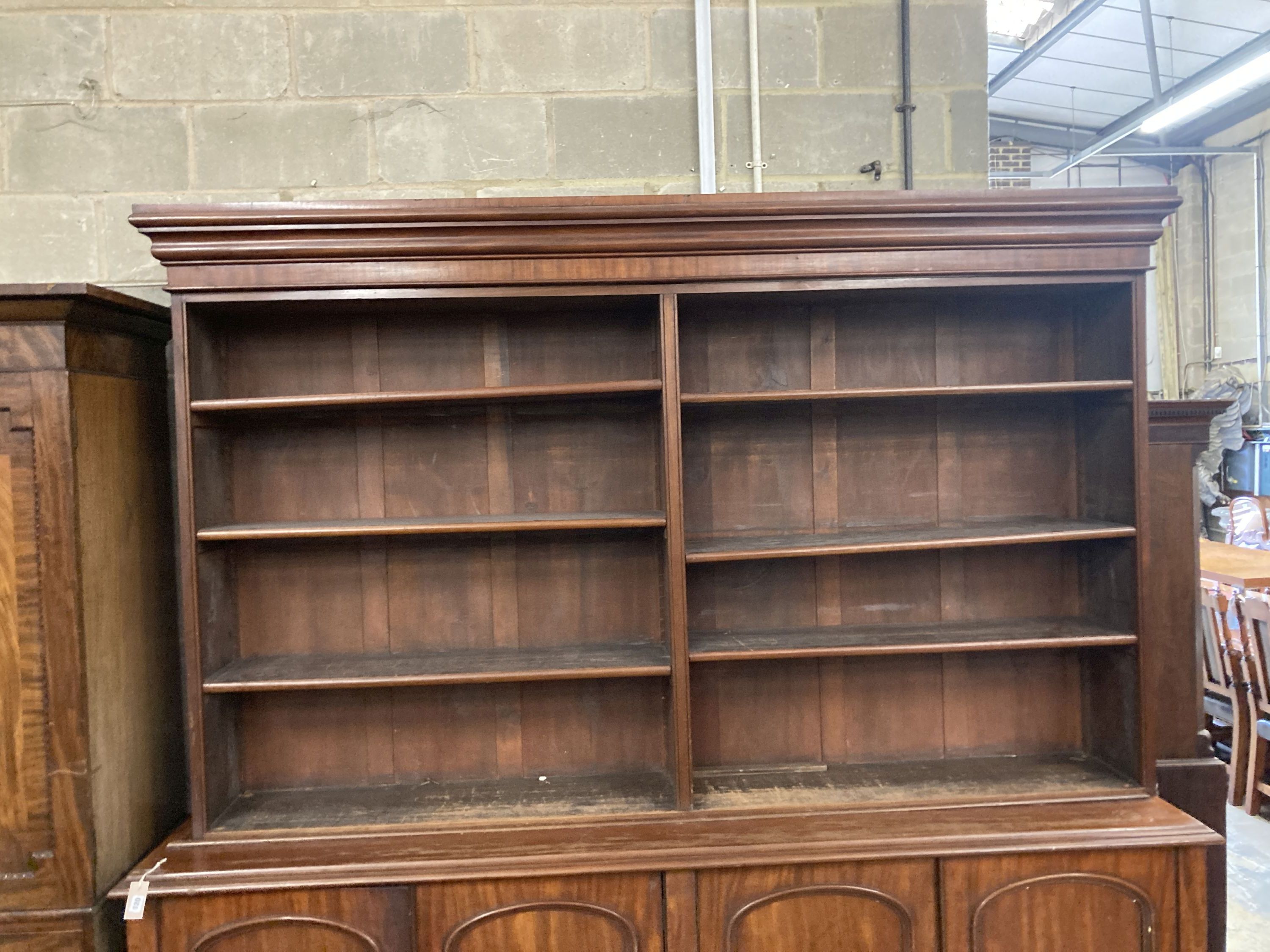 A Victorian mahogany library bookcase, the open shelves over an enclosed four door base, length 230cm, depth 50cm, height 238cm